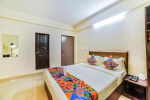 a bedroom with a large bed with colorful pillows at FabHotel K7 Trends With Pool, Baga Beach - Nr Baga Beach in Calangute