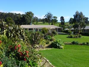 einen Garten mit einem Haus im Hintergrund in der Unterkunft Port Arthur Villas in Port Arthur