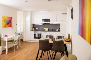 una cucina e una sala da pranzo con tavolo e sedie di Cityapartment Dornbirn 50 qm a Dornbirn