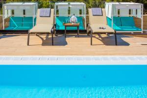 - un groupe de chaises assises à côté de la piscine dans l'établissement Golden Costa Salou - Adults Only 4* Sup, à Salou