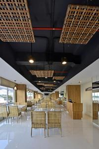 d'une salle à manger avec des tables, des chaises et des plafonds noirs. dans l'établissement Whiz Prime Hotel Basuki Rahmat Malang, à Malang