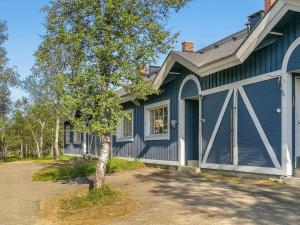 una casa azul con un árbol delante en Holiday Home Tunturikuksa by Interhome en Saariselka