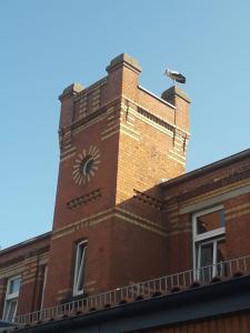 um edifício de tijolos com uma torre de relógio em cima em Pension Töpferhof em Tangermünde