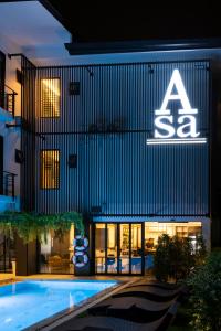 uma placa na lateral de um edifício com piscina em Asa Hotel em Chiang Mai