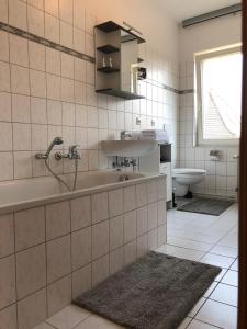 ein Badezimmer mit einer Badewanne, einem Waschbecken und einem WC in der Unterkunft Viadrina Rooms & Apartments Frankfurt-Oder am Park im Zentrum in Frankfurt (Oder)