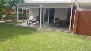 een afgeschermde veranda met stoelen en een tafel bij Bungalows Los Melocotones in Maspalomas