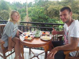 Un uomo e una donna seduti a un tavolo con del cibo di Jero Ratna Homestay ad Ubud