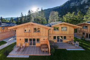 Casa de madera grande con terraza con sillas en Zugspitz Lodge en Ehrwald