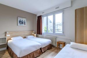 een hotelkamer met 2 bedden en een raam bij Comfort Hotel Rouen Alba in Rouen