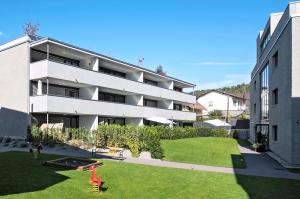 um edifício de apartamentos com um relvado em frente em Relaxed Urban Living - Aparthotel und Boardinghouse em Dornbirn