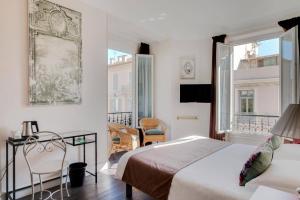 um quarto com 2 camas, uma mesa e cadeiras em Hotel Select em Beaulieu-sur-Mer