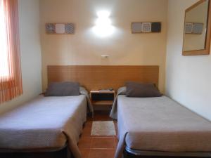 Zimmer mit 2 Betten und einem Tisch in der Unterkunft Hostal El Callejón in Tarragona