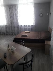 Schlafzimmer mit einem Bett, einem Tisch und Stühlen in der Unterkunft Studio on Stefan 37 in Bălţi