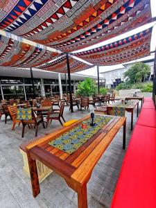 un patio con mesas y sillas bajo un techo en ONOMO Hotel Durban en Durban