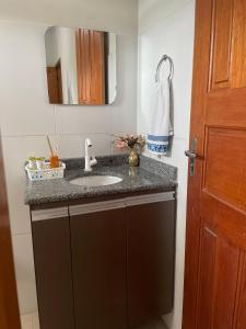 a bathroom with a sink and a mirror at Flat hotel Victoram in Rio Branco