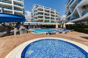 uma piscina ao lado de um grande edifício de apartamentos em SA Apartments! Crystal Family Apartments em Alanya