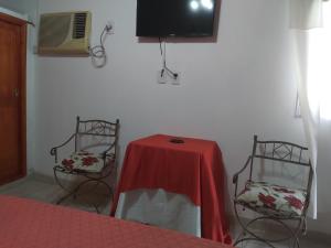 um quarto com uma mesa e duas cadeiras e uma televisão em Las orquídeas em Goya