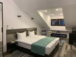 1 dormitorio con 1 cama y 2 sillas en ARTE Hotel rooms & apartments, en Veliko Tŭrnovo