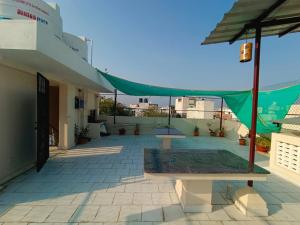 eine Terrasse mit einem grünen Zelt auf einem Gebäude in der Unterkunft VILLA DE SRIVAARI RESIDENCY in Puducherry