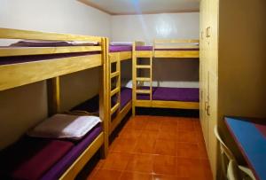 バギオにあるRedDoorz Hostel MRC Residences Baguioの二段ベッド3組と廊下が備わる客室です。