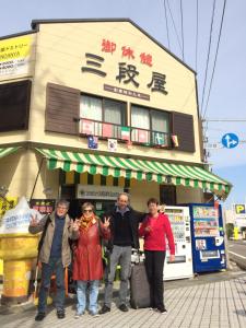 um grupo de pessoas em pé em frente a um edifício em Dormitory Sandanya Guesthouse em Shirahama