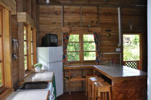 a kitchen with a refrigerator and a counter top at Castara Villas in Castara