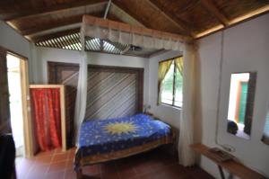 um quarto com uma cama num quarto com janelas em Castara Villas em Castara