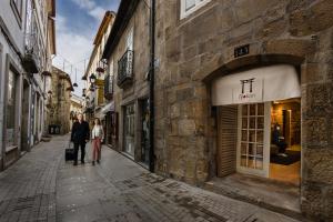 een man en een vrouw die over straat lopen bij Viseu Ryokan - Hospedaria Japonesa & SPA in Viseu