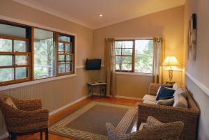 sala de estar con sillas, sofá y ventanas en Barrington Hideaway- River Cottages, en Gloucester