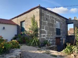 Casa em Resende com Vista Para o Rio Douro في ريزندي: منزل حجري قديم مع مرآب أبيض