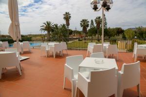 un patio con mesas blancas y sillas blancas en INATEL Porto Santo en Porto Santo