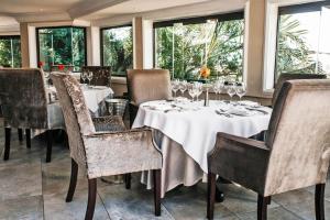 a dining room with tables and chairs and windows at The View Boutique Hotel & Spa in Amanzimtoti