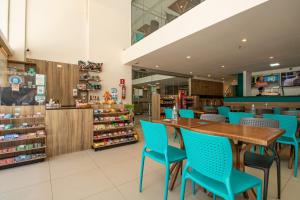 un restaurant avec des chaises bleues et une table en bois dans l'établissement Acqua Inn Maceió Ponta Verde, à Maceió