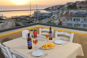 uma mesa com garrafas e copos de cerveja e comida em Horasan Boutique Hotel em Cesme