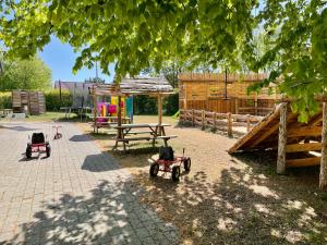 um parque infantil com tractores de brinquedo num quintal em Hestkær Family Rooms em Grindsted