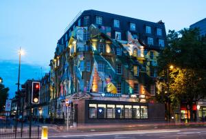 un edificio en una calle de la ciudad con un semáforo en Megaro Hotel en Londres