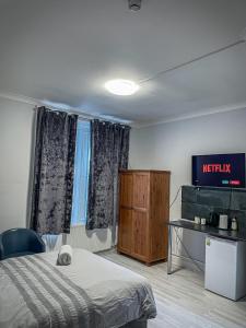 une chambre d'hôtel avec un lit et une télévision dans l'établissement The New George Hotel, à Newcastle upon Tyne