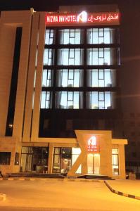 a large building with a sign on top of it at Nizwa Inn - نزوى إن in Nizwa