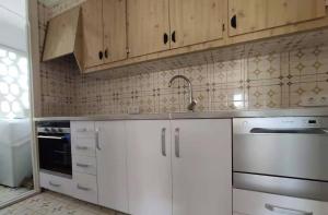 uma cozinha com armários brancos e um lavatório em FIRST LINE SEASIDE - 1 Bedroom BENICASSIM TORREON em Benicàssim