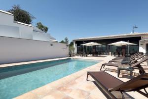 una piscina con sillas y sombrillas junto a un edificio en Áurea Washington Irving by Eurostars Hotel Company, en Granada