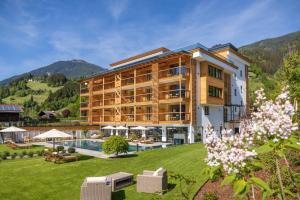 a large building with a yard with a pool at Natur Resort RISSBACHER in Stumm