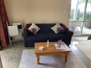 a living room with a couch and a coffee table at The Back Garden in Waihi Beach