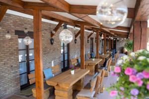 una fila de mesas y sillas en un restaurante con luces en Hotel Monika en Zutendaal