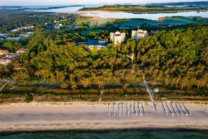 Cliff Hotel Rügen في اوستيباد سيلين: اطلالة جوية على شاطئ به اشجار ومدينة