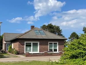 een stenen huis met een bank ervoor bij Lüttje Najade Ruhige, zentrale Lage am Rande des Kurparks. Wenige Gehminuten zum Strand und in die Innenstadt. Neu renovierte und liebevoll eingerichtete Wohnung. in Borkum