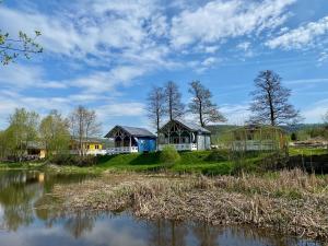 um grupo de chalés numa colina junto a um lago em Osada Pstrąga em Stronie Śląskie