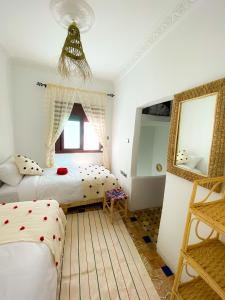 1 Schlafzimmer mit 2 Betten und einem Spiegel in der Unterkunft DAR ADIL KASBAH in Tangier