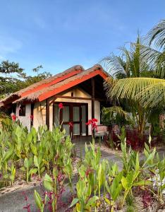 塞隆貝拉納克的住宿－Burudika Bungalows，一座有红色屋顶和一些植物的房子