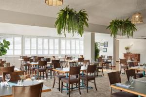 um restaurante com mesas, cadeiras e janelas em ibis Styles Tamworth em Tamworth