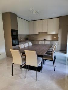 cocina grande con mesa de madera y sillas en Vomikay Villa en Tallin